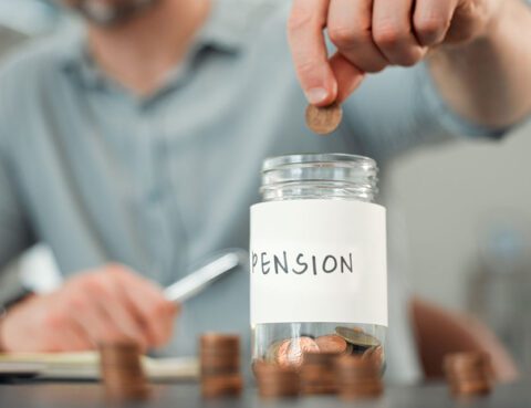 Man putting money into a jar labeled pension.