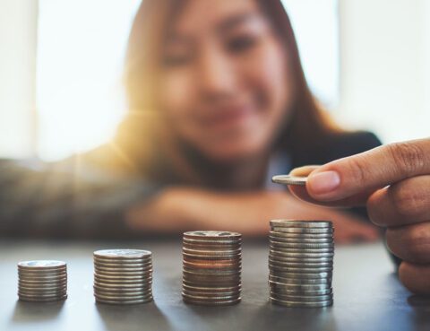 Woman counting stacks of coins.