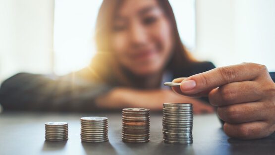 Woman counting stacks of coins.