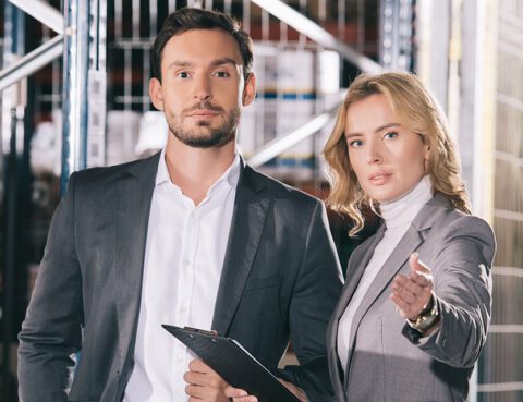 Business woman with a clipboard and a male client observing his business operations.