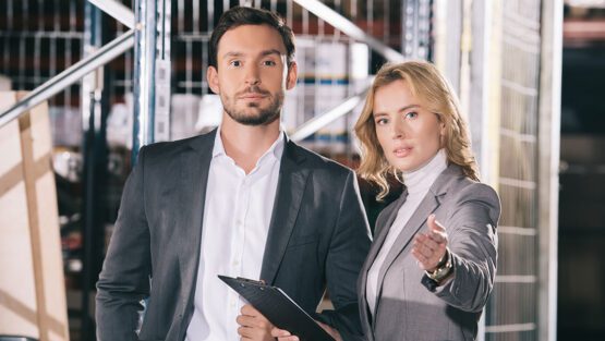 Business woman with a clipboard and a male client observing his business operations.
