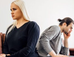 Couple sitting apart on a couch reflecting tension during divorce and long-term financial decisions
