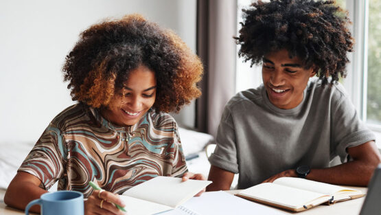 Two children studying together, representing the long-term financial planning involved in child related expenses after divorce.